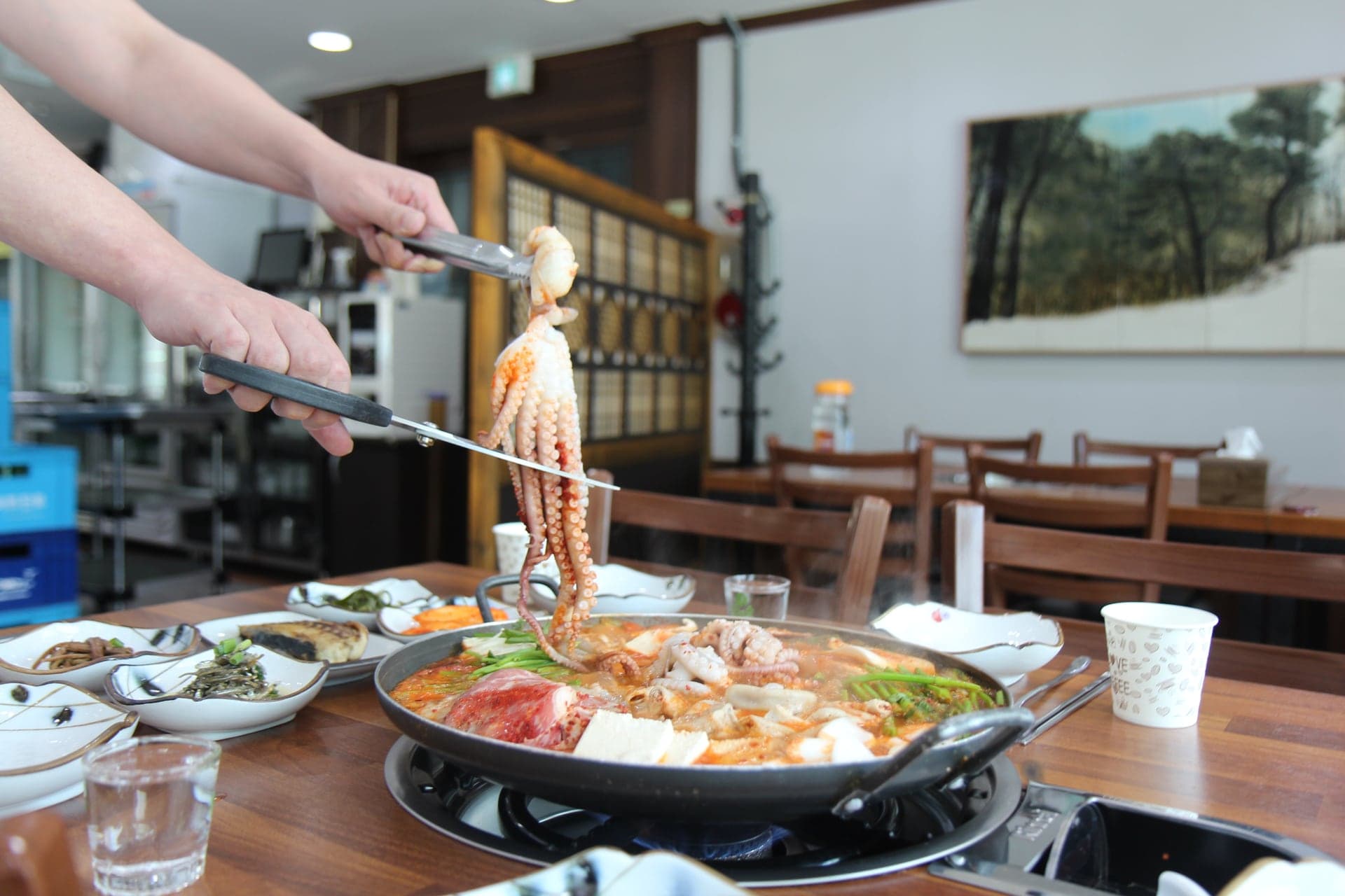 끓는 전골 위에서 낙지를 손질하는 모습