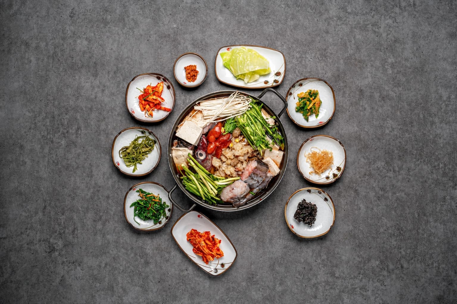 Seafood hot pot with neatly arranged side dishes